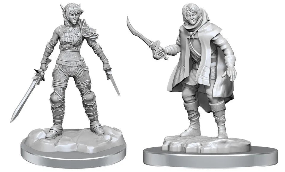 Divas pelēkas plastmasas D&D miniatūras: elfes un pusaudža zagļa figūras ar ieročiem uz apaļām pamatnēm.