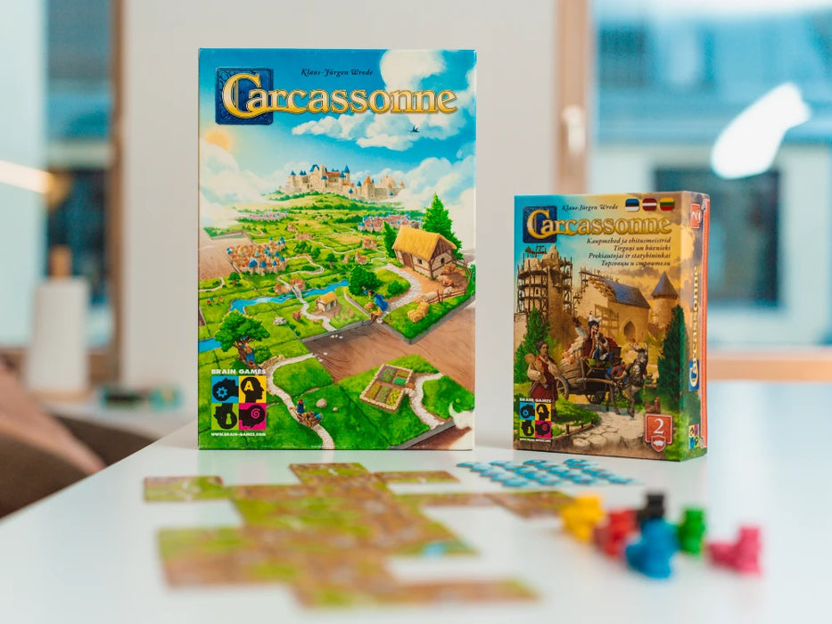 Carcassonne pamatspēle un paplašinājums Tirgoņi un būvnieki ar krāsainiem spēles lauciņiem un koka figūriņām uz galda.