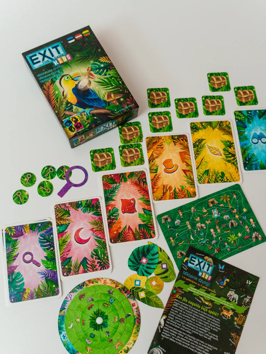 EXIT Kids: Mīklainie džungļi galda spēle ar krāsainām mīklu kārtīm, dārgumu lādēm, palielināmo stiklu un spēles instrukciju.