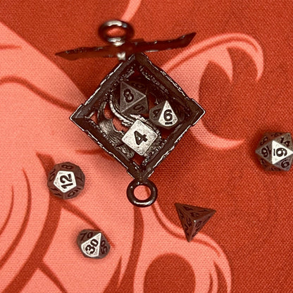 Sudraba krāsas metāla D6 kauliņa formas atslēgu piekariņš ar septiņiem 5 mm miniatūriem galda spēļu kauliņiem.