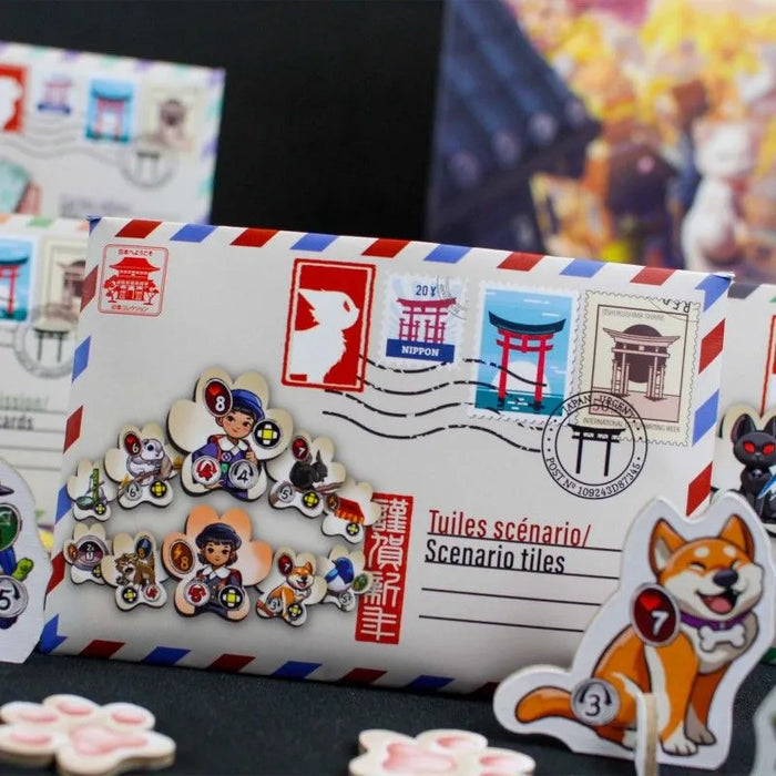 Kyoto no Neko galda spēles kartona scenāriju flīzes aploksnē ar japāņu stila pastmarku ilustrācijām un krāsainiem tēliem.