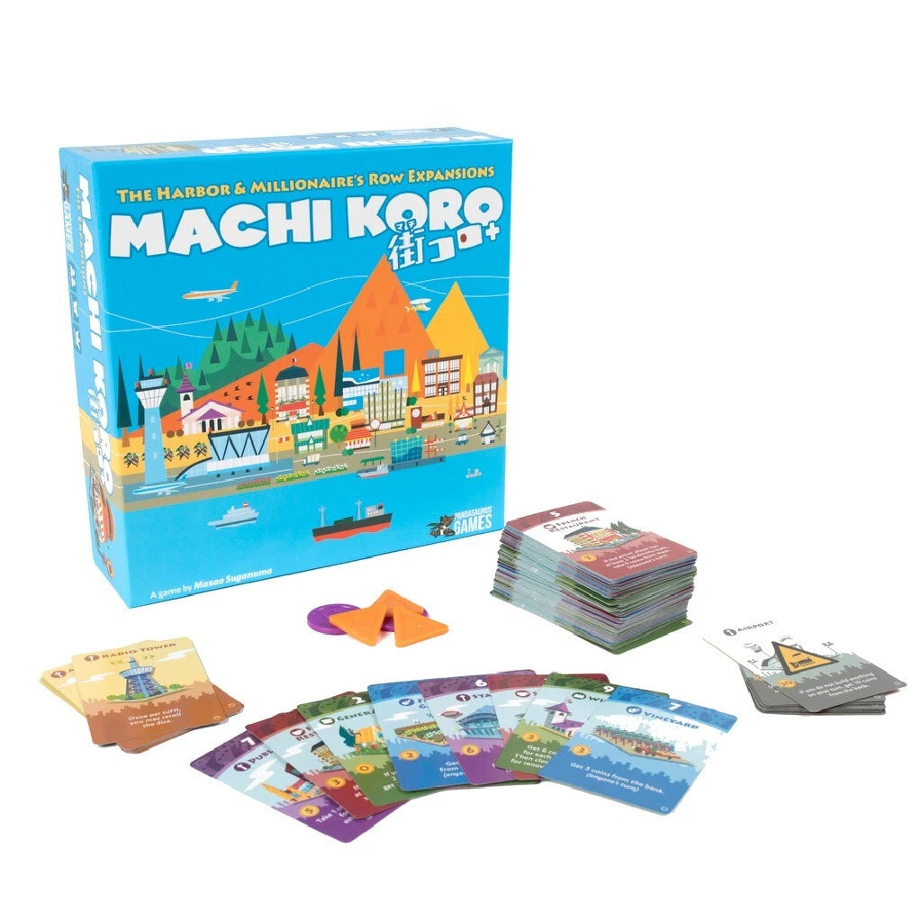 Machi Koro 5th Anniversary papildinājuma kaste ar krāsainām spēļu kārtīm un plastmasas žetoniem uz balta fona.