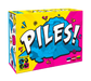 Krāsaina galda spēles Piles! kaste ar dzeltenu un rozā dizainu, uz kuras attēlota zila apģērbu kaudze un lieli balti burti.