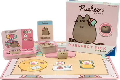 Pusheen kāršu spēle ar rozā spēles laukumu, ilustrētām kārtīm un mazu Pusheen figūriņu uz galda.