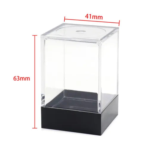 Caurspīdīga plastmasas kastīte 7 galda spēļu kauliņu uzglabāšanai ar melnu pamatni un izmēriem 41x63 mm.