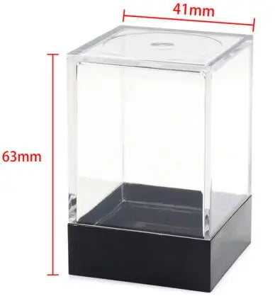Caurspīdīga plastmasas kastīte 7 galda spēļu kauliņu uzglabāšanai ar melnu pamatni un izmēriem 41x63 mm.