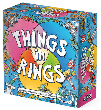 Things in Rings galda spēles kaste ar krāsainu Venna diagrammas dizainu un dažādu priekšmetu ilustrācijām uz zila fona.